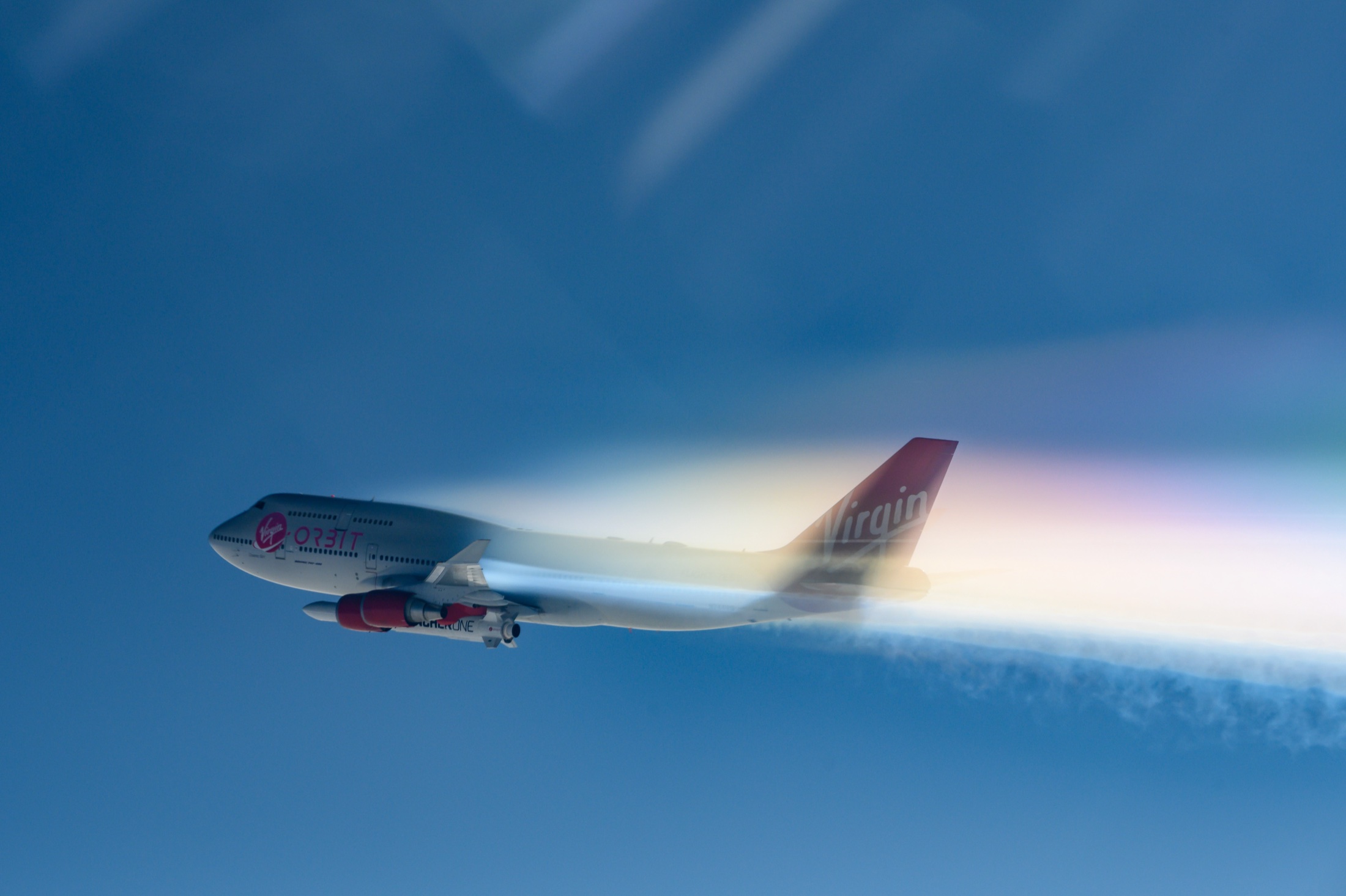 Cosmic Girl and LauncherOne in flight above the clouds.